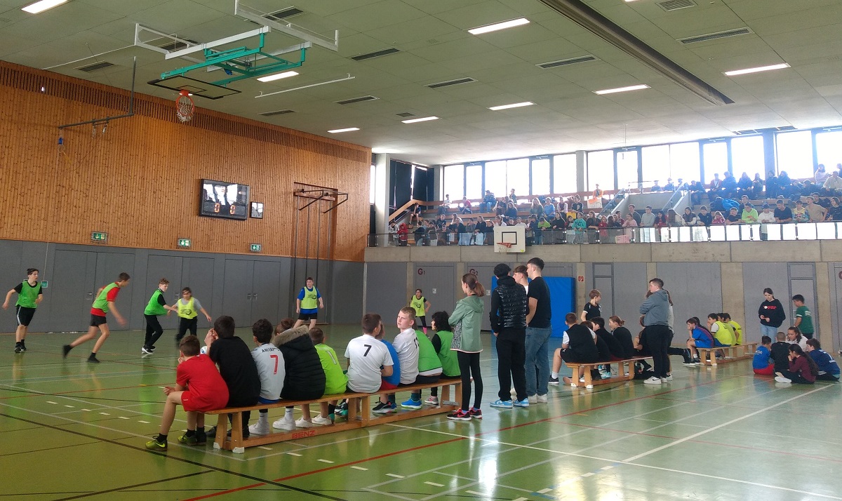 Fußball spielende und zuschauende Kinder beim Turnier
