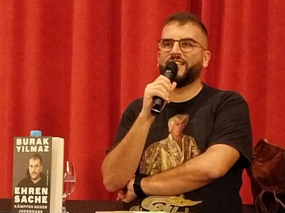 Burak Yilmaz hinter einem Stehtisch