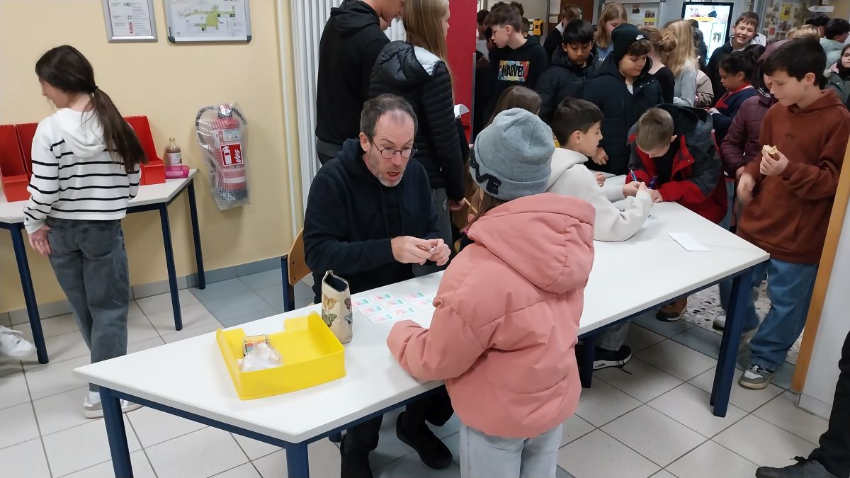 Lehrkraft verkauft ein Stickeralbum