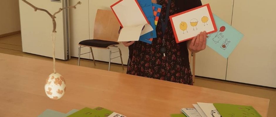 Schüler*in präsentirt gebastelte Osterkarten