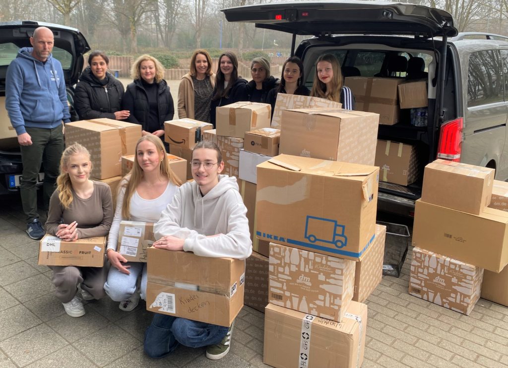Schüler*innen vor Paketstapel