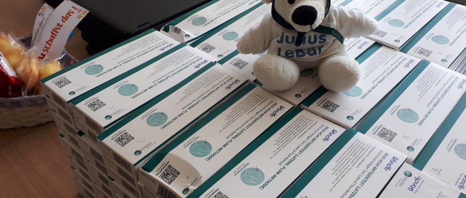 Teddy auf Stapel Coronaschnelltest Packungen